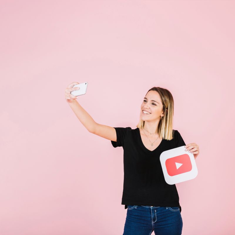 an influencer clicking a selfie with a YouTube play button cut-out